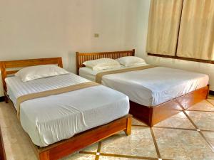 Postel nebo postele na pokoji v ubytování Nakasang Paradise Hotel
