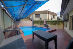 a swimming pool on a patio with a table and an umbrella at KSF Place Alaka in Lagos