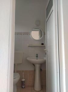 La salle de bains est pourvue d'un lavabo, de toilettes et d'un miroir. dans l'établissement Angelina Studios, à Kardamaina