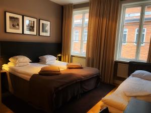 a bedroom with two beds and two windows at Hotel Villan in Gothenburg +70 photos
