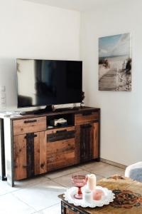 una sala de estar con TV en un centro de entretenimiento de madera en Vulkanland Stoeckel - Feldbach, en Feldbach