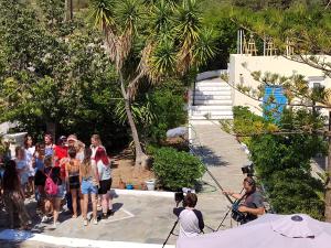 un groupe de personnes debout sur une plage avec une caméra dans l'établissement Lianos Hotel Apartments, à Spetses