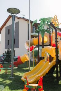 un parque infantil con un tobogán en el césped en Villa Monica Apartamenty en Szczyrk