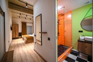 ein Bad mit einer Dusche, einem Waschbecken und einem Spiegel in der Unterkunft Rooms Apart-Hotel by RED in Yerevan