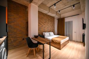 een slaapkamer met een bed en een houten tafel en stoelen bij Rooms Apart-Hotel by RED in Jerevan