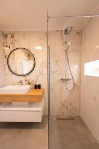 La salle de bains est pourvue d'une douche, d'un lavabo et d'un miroir. dans l'établissement Villa Coral, à Vrelo Bosne