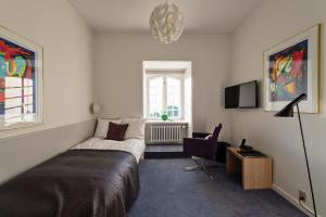 1 dormitorio con 1 cama, 1 silla y 1 ventana en Konventum Conference Center, en Helsingør