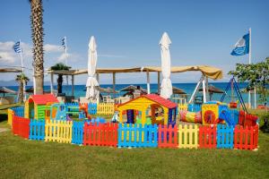 a colorful play set on the grass near the beach at Xerxis Studios in Nea Roda