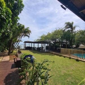 un parque con un pabellón y el océano al fondo en Jurerê Beira Mar Residence, en Florianópolis