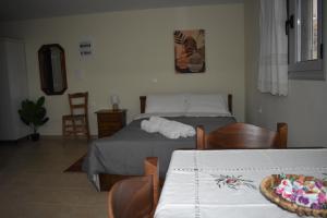 1 dormitorio con 2 camas, mesa y sillas en Tzoumerka Guest House, en Rámia