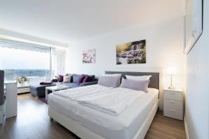 um quarto branco com uma cama grande e um sofá em Ferienwohnung Landblick App 162 em Timmendorfer Strand