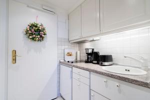 uma cozinha com armários brancos e um lavatório em Ferienwohnung Landblick App 162 em Timmendorfer Strand