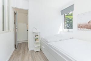 ein weißes Schlafzimmer mit einem Bett und einem Fenster in der Unterkunft Ferienwohnung Die 2b in Timmendorfer Strand