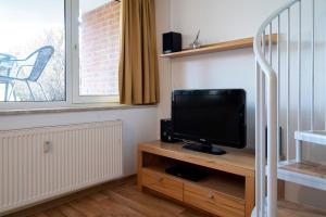a television sitting on a wooden stand in a room at Ferienwohnung Sandburg App 27a in Timmendorfer Strand