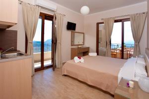 um quarto de hotel com uma cama e uma varanda em Calm View em Vasiliki
