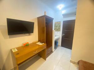 a room with a desk and a television on the wall at Villa Matano Sorowako 2 Redpartner in Saroako