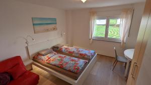 a bedroom with a bed and a red couch at Gästehaus Freystadt in Freystadt