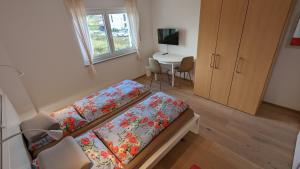 a bedroom with a bed and a table with a television at Gästehaus Freystadt in Freystadt