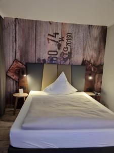 a bedroom with a white bed with a wooden wall at Hotel Bavaria Oldenburg in Oldenburg