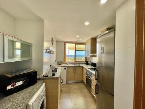 uma cozinha com um frigorífico de aço inoxidável e um lavatório em Remarkable 1-Bed Apartment & Sea Views - Sleeps 2 em Finestrat