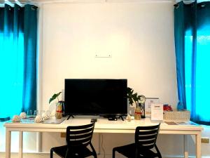 a desk with two chairs in a room with blue curtains at Davao Airport View Hotel in Davao City