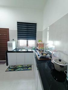 eine Küche mit einer Theke mit einem Waschbecken und einem WC in der Unterkunft Homestay Kemaman Fyna07 Banglo Mewah 5 KM Dari Pantai Kijal in Kijal