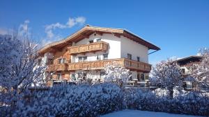 une maison dans la neige avec des arbres devant elle dans l'établissement Haus Bianca, à Stumm