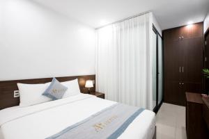 sypialnia z dużym białym łóżkiem i szafą w obiekcie Aui Hotel w mieście Ðoan Xá