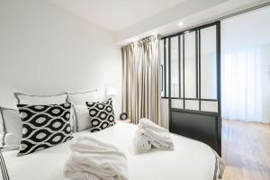 - une chambre avec un lit blanc et des oreillers noirs et blancs dans l'établissement Luxury Apartment 100 m to Palais des Festivals, à Cannes