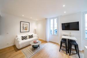 - un salon blanc avec un canapé blanc et une télévision dans l'établissement Luxury Apartment 100 m to Palais des Festivals, à Cannes