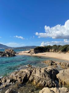 una spiaggia sabbiosa con rocce in acqua di Magnifique villa récente entre mer et montagne située entre Ajaccio et Porticcio a Cauro