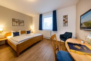 a hotel room with a bed and a table and chair at Land gut Hotel Hermann in Bentwisch