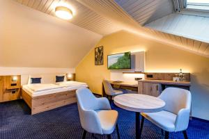 Schlafzimmer mit einem Bett, einem Tisch und Stühlen in der Unterkunft Land gut Hotel Hermann in Bentwisch
