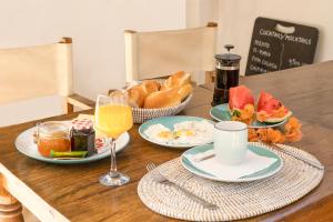 a table with plates of food and a basket of bread at Casa Louka in Saly Portudal