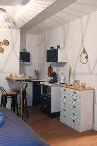 eine kleine Küche mit einem Tisch und einer Theke in der Unterkunft L'Acacia #Hyper-centre #Marché couvert in Cognac