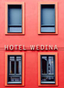 een rood gebouw met drie ramen en een hotel weiden bij Hotel Wedina an der Alster in Hamburg