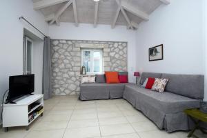 salon z kanapą i telewizorem w obiekcie Wild Sea Apartments w mieście Agios Nikitas