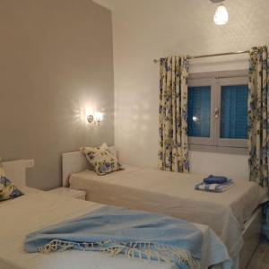 1 Schlafzimmer mit 2 Betten und einem Fenster in der Unterkunft desert pearl beautiful cosy new home in Luxor