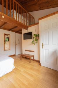 una camera con letto e pavimento in legno di Hôtel & Restaurant La Ferme Du Pommeau a La Plaine-des-Palmistes