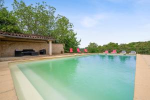 una grande piscina con sedie e un edificio di Villa spacieuse avec piscine privée, à Salies, 250 m², 6 chbres a Saliès Altre 2 foto