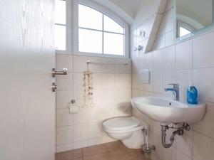 baño con lavabo y aseo y ventana en Ferienhaus To Hus en Vieregge