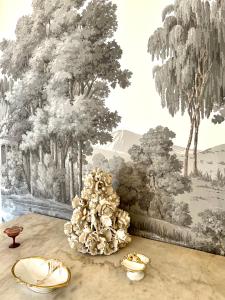 a table with a flower arrangement in front of a wall at Castiglione 27 Luxury Suite in Bologna +74 photos