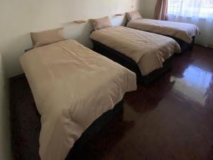 two twin beds in a room with at Simbia Contractors Inn in Vaalpark