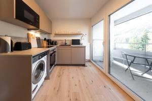 une cuisine avec un lave-linge, un sèche-linge et une table dans l'établissement Apartment Alpenblick, à Ellmau