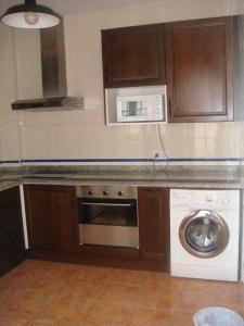 a kitchen with a washing machine and a microwave at Casa La Rocina Almonte in Almonte