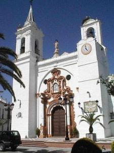 una gran iglesia blanca con una torre de reloj en Casa La Rocina Almonte, en Almonte