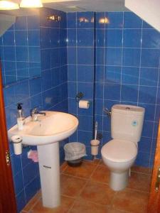 a blue tiled bathroom with a toilet and a sink at Casa La Rocina Almonte in Almonte