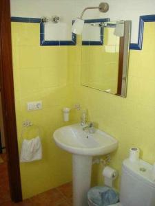 a bathroom with a sink and a mirror and a toilet at Casa La Rocina Almonte in Almonte