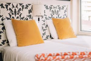 - une chambre avec un lit et des oreillers jaunes dans l'établissement Boutique Lodge Zandvoort, à Zandvoort