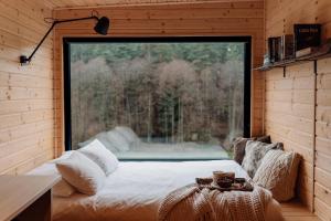 a bed in a room with a large window at Na skraju gaju in Purda